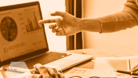 Reunión de trabajo con análisis de datos en un portátil.
